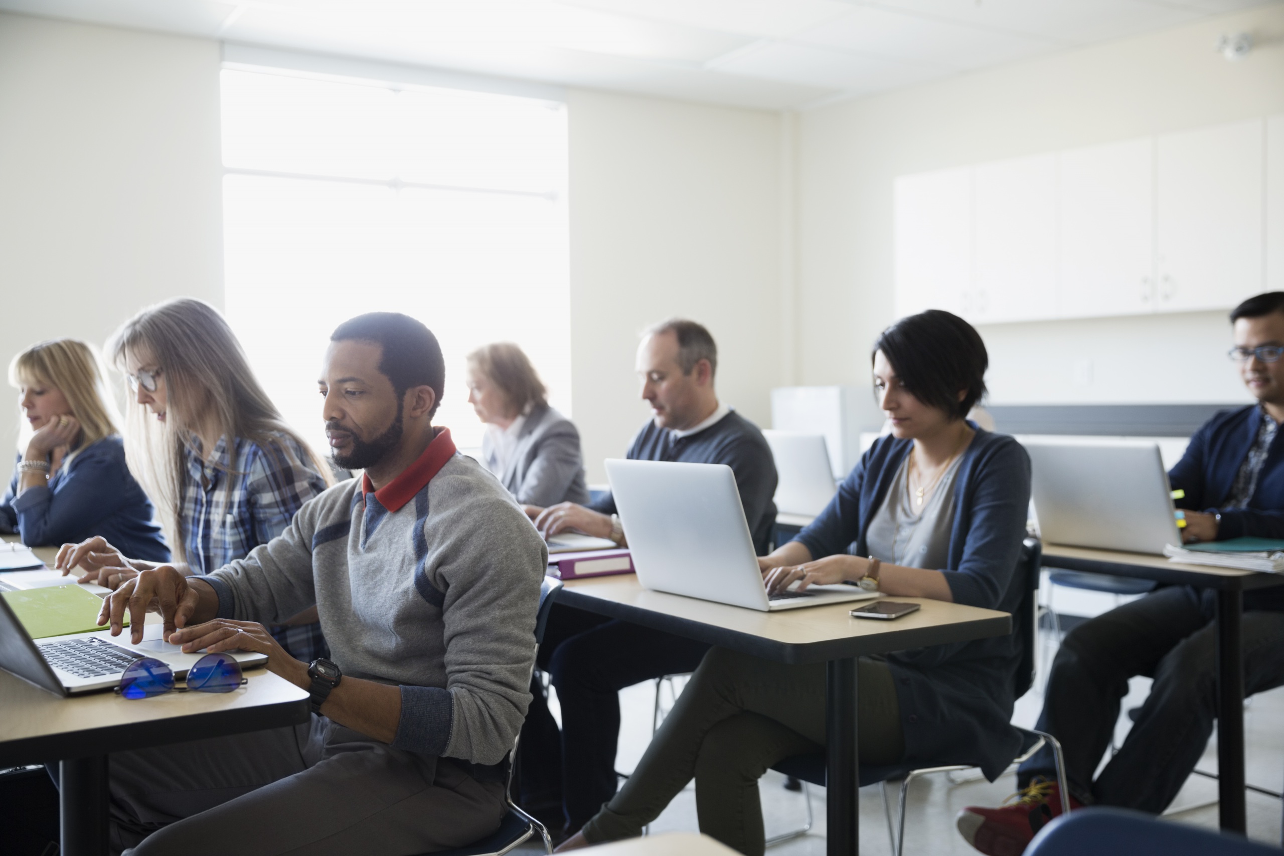 Adult learners working together in a bright classroom